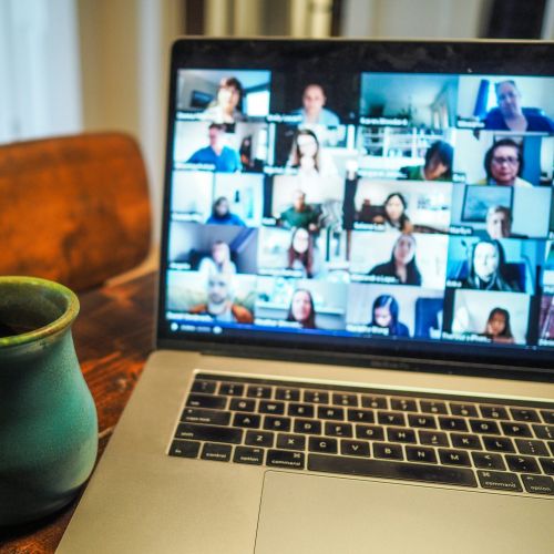 Tasse und Computer mit einen geöffneten Onlinemeeting